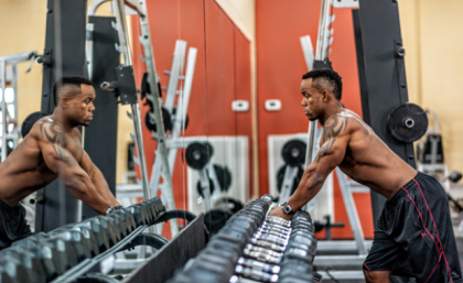 Man looking at himself in the mirror at a gym